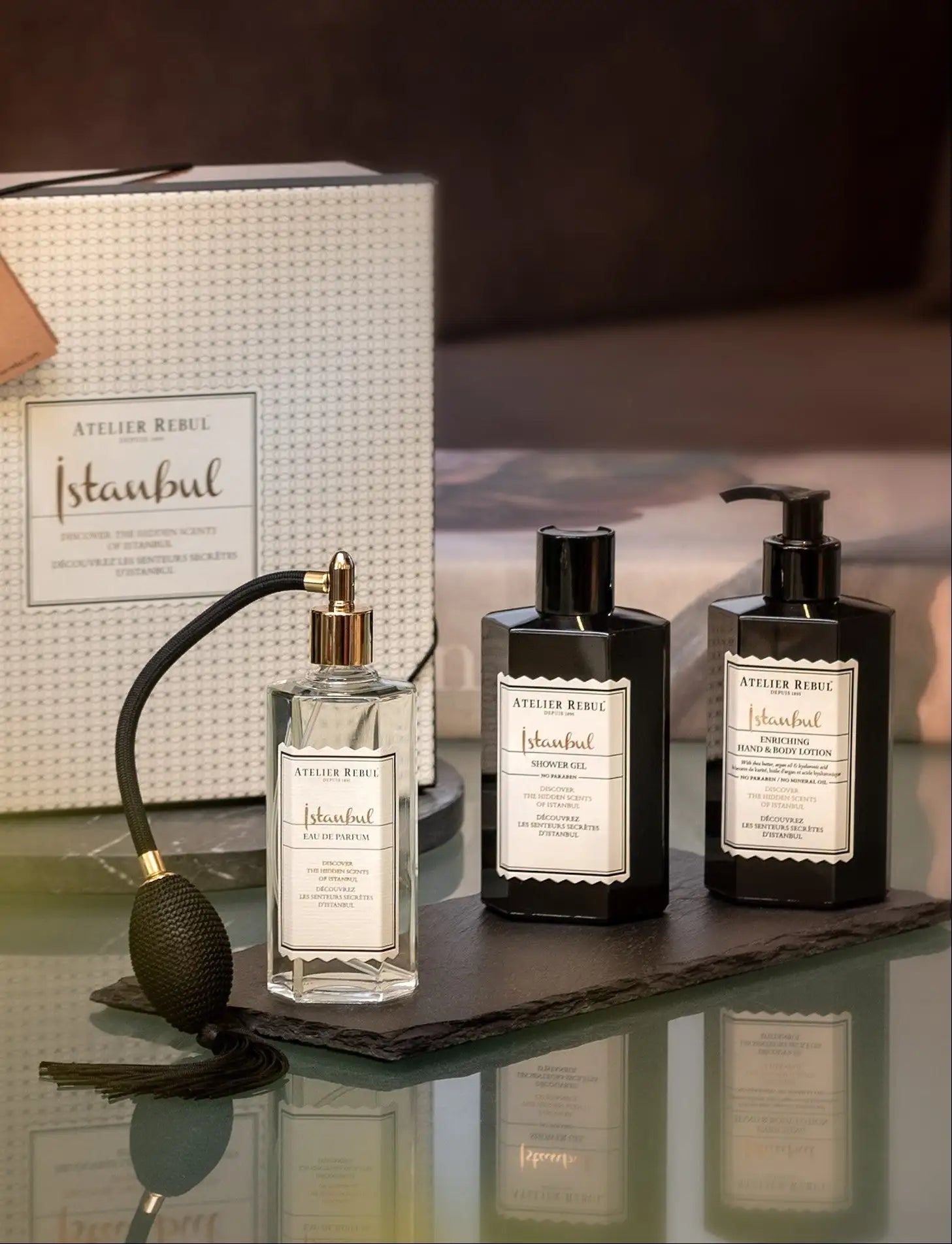 Sticlă de parfum din sticlă transparentă cu duză de pulverizare de ton auriu și pompă texturată neagră, cu etichetă albă elegantă pentru parfumul ’istanbul’ de la atelier rebul.